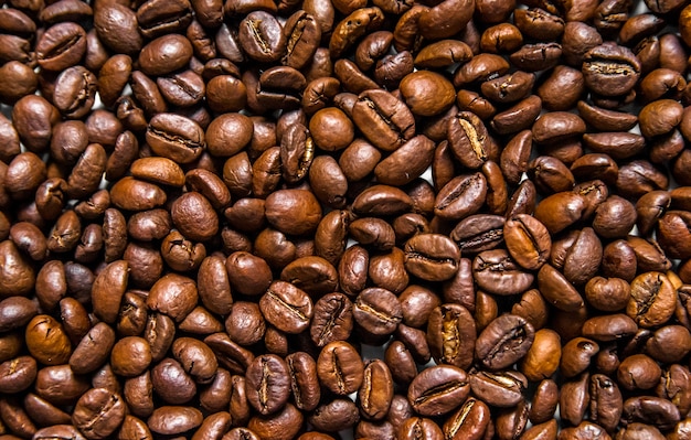 異なる種類のコーヒー豆の混合物。コーヒーの背景。焙煎コーヒー豆。白い背景にあるコーヒー豆