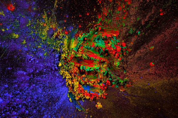 Mixture of holi color powder spread over dark background
