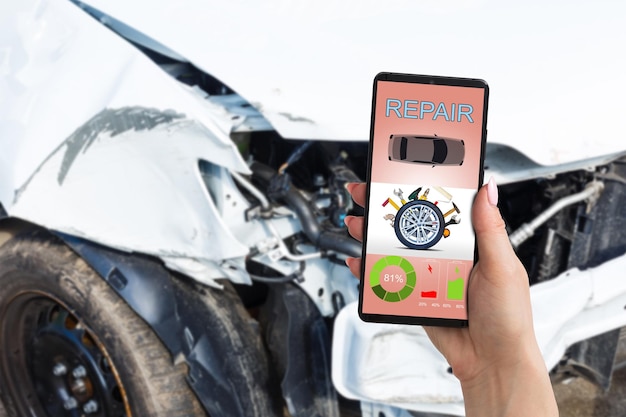 Mobile phone in hand on car repair service center blurred background.