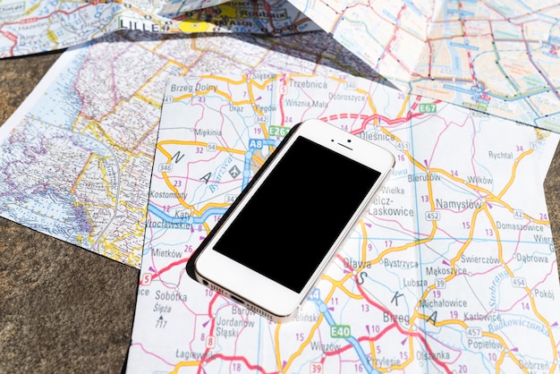 Бесплатное фото Мобильный телефон на туристических картах польши