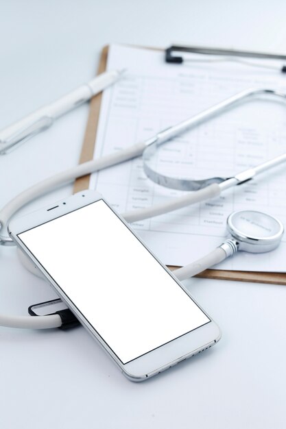 Mobile phone, stethoscope and chart file on the desktop (mobile medical, handheld doctor concepts)