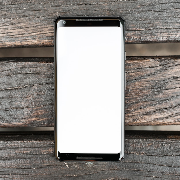 Mobile phone with white screen display on wooden textured plank