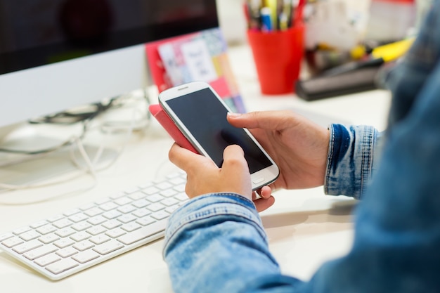 Mobile phone in a woman's hand. Indoor image.