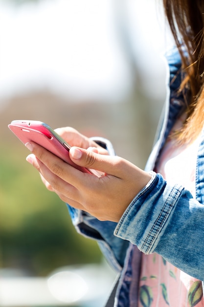 女性の手の中の携帯電話。屋外イメージ。