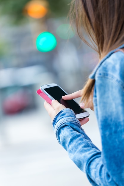 女性の手の中の携帯電話。屋外イメージ。