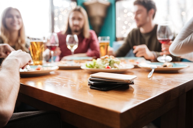 Mobile phones on table. Friends sitting in cafe.