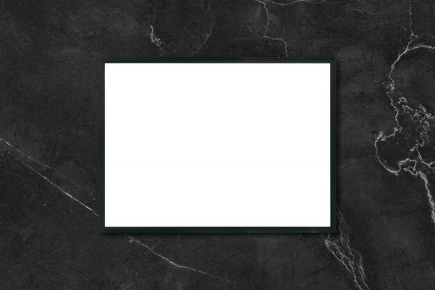部屋の黒い大理石の壁にぶら下がっている空のポスターの額縁をモックアップする - モンタージュ製品の表示とデザインのキービジュアルレイアウトのモックアップに使用できます。