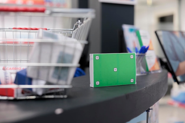 Foto gratuita simula un prodotto farmaceutico con schermo verde in piedi sul bancone in farmacia vuota, spazio pieno di pillole e vitamine pronte per i clienti. concetto e servizio di supporto medico