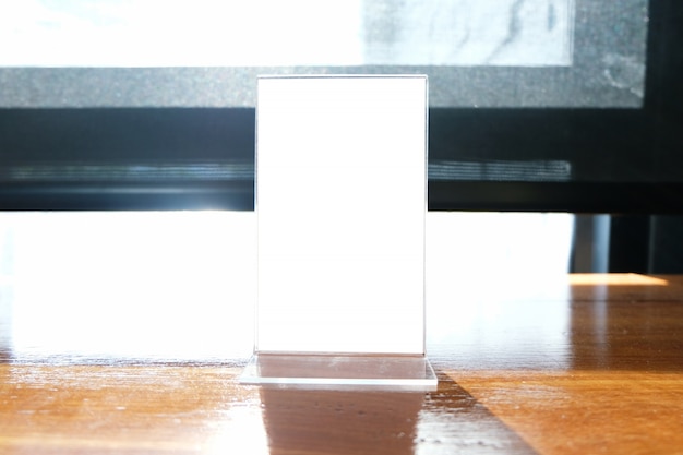 Mock up menu frame standing on wood table in bar restaurant cafe. space for text