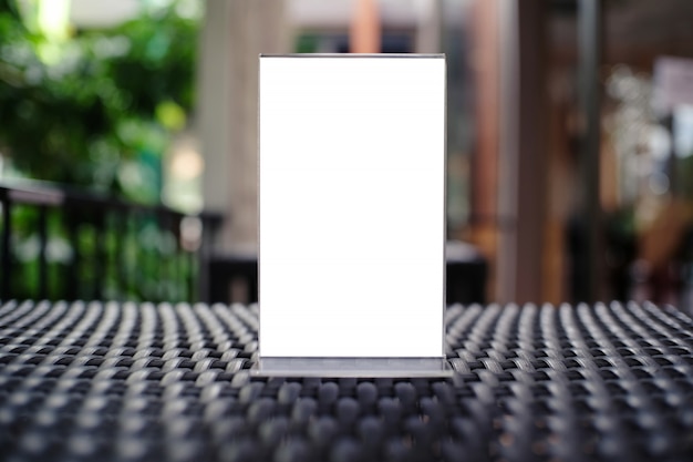 Mock up menu frame standing on wood table in bar restaurant cafe. space for text.