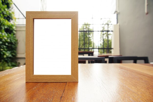 Mock up menu frame standing on wood table in bar restaurant cafe. space for text.