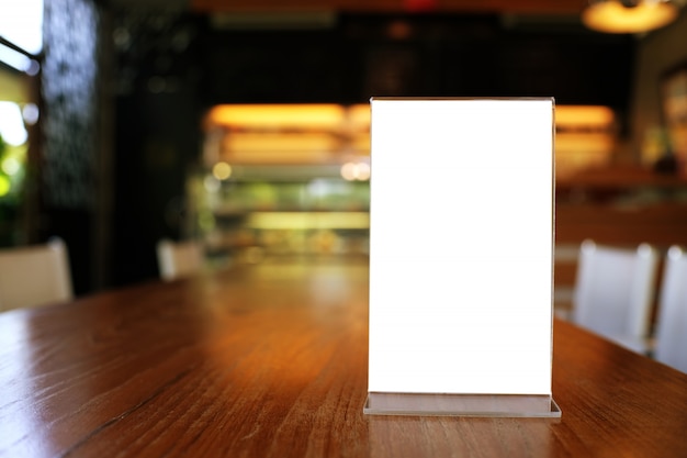 Mock up menu frame standing on wood table in bar restaurant cafe