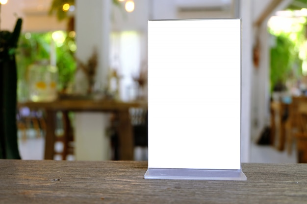 Mock up menu frame standing on wood table in bar restaurant cafe