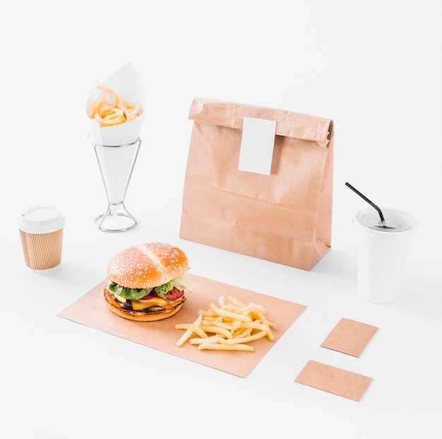 Free photo mock up set of burger; french fries; parcel and disposal cup on white surface