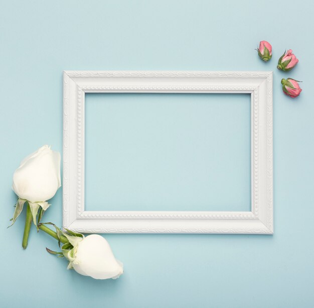Mock-up white horizontal empty frame with rosebuds on blue background