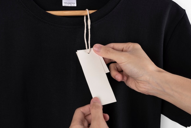 モックアップ空白の黒いtシャツと広告のための空白のラベルタグ。