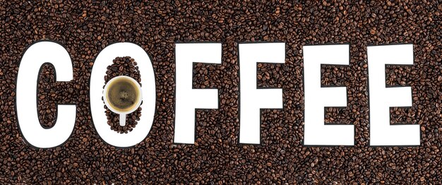 Мокет кофейных зерен в виде слова кофе и чашки эспрессо сверху