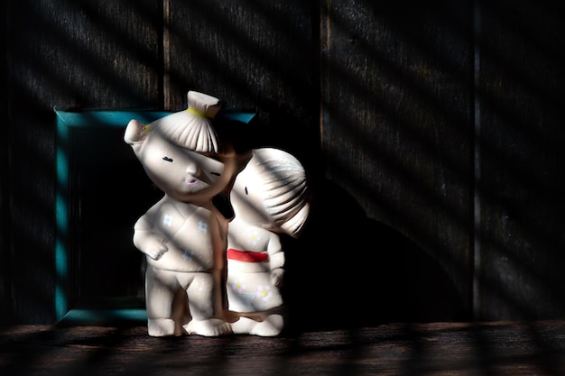 Mockup frame and old couple doll on hard shadows wooden background.