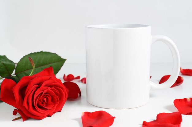 발렌타인 데이를 위한 낭만적인 구성의 빨간 장미가 있는 나무 탁자에 있는 흰색 머그