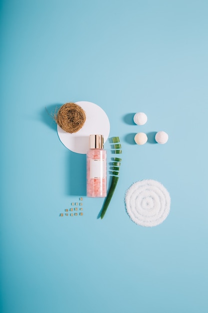 Mockup spa bottle with pink bath salt on blue background. copy space