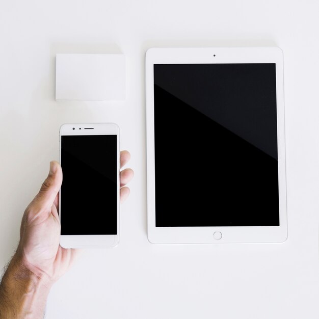 Mockup with hand holding smartphone and tablet