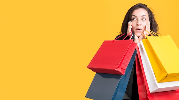 Model being covered by shopping bags copy space