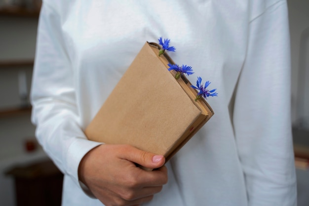 Model holding book with flowers front view