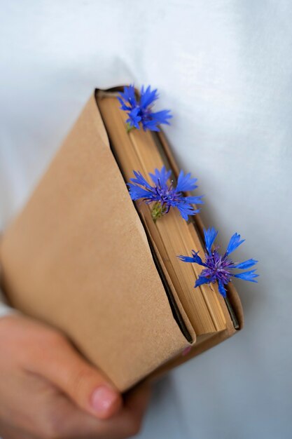 Model holding book with flowers high angle