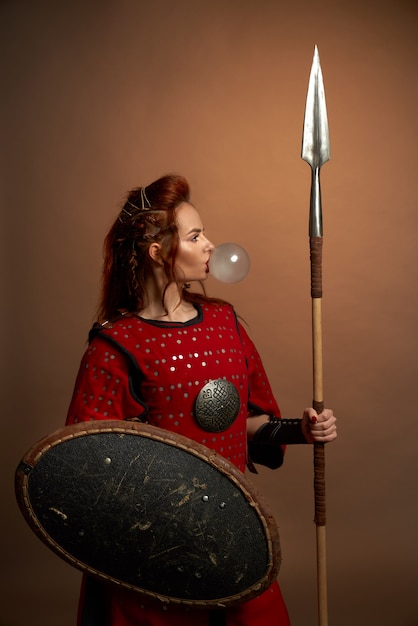 Free photo model in medieval costume posing, blowing bubble gum.