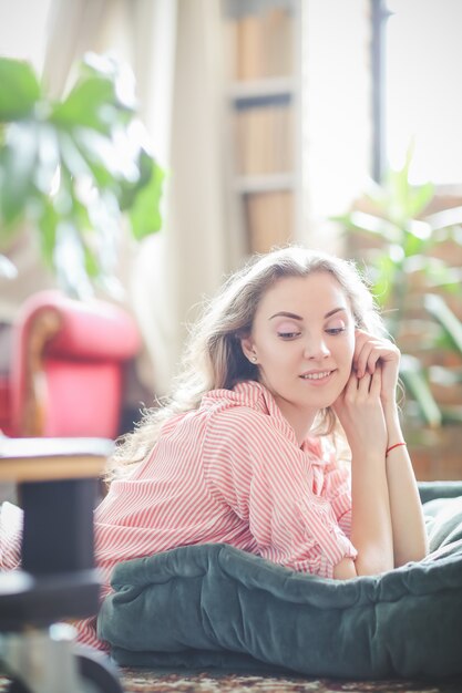 Model in pink shirt lying on the puff