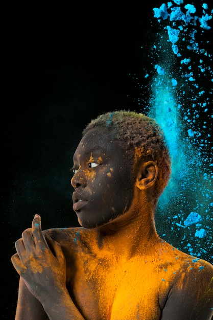 Model posing with yellow and blue powder medium shot