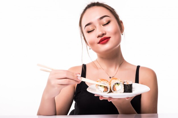 Model shows pleasure after having sushi rolls meal holding chopsticks