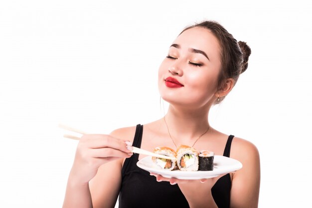 Model shows pleasure after having sushi rolls meal holding chopsticks