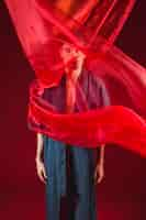 Free photo model standing and posing with red cloth