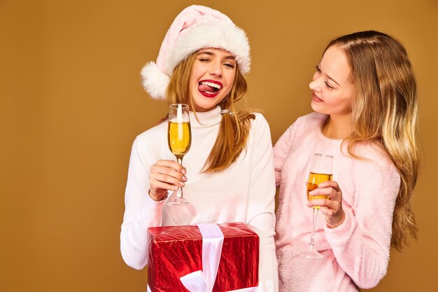 新年を祝うグラスでシャンパンを飲む大きなギフトボックスを持つモデル
