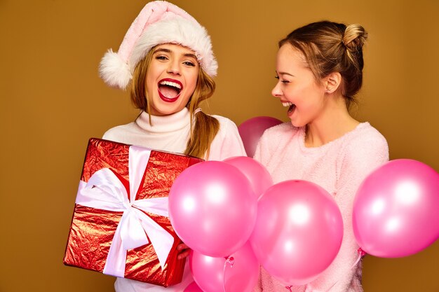 Models with big gift box and pink balloons on Christmas 