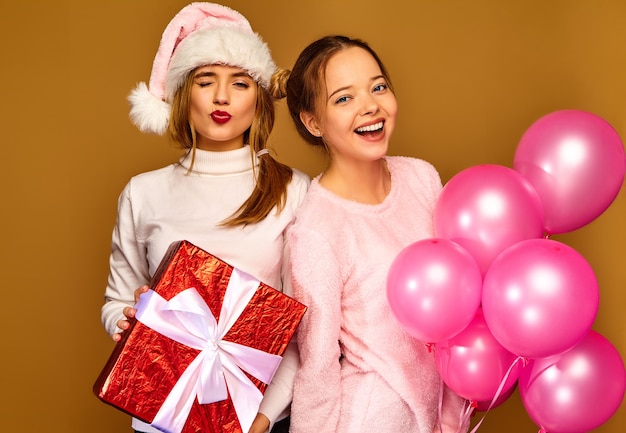 Modelli con grande confezione regalo e palloncini rosa a natale