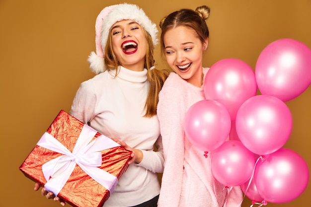 Models with big gift box and pink balloons on Christmas 
