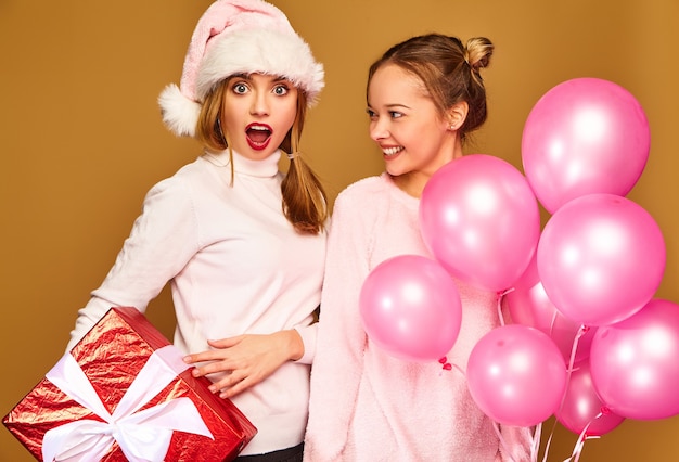 Modelli con grande confezione regalo e palloncini rosa a natale