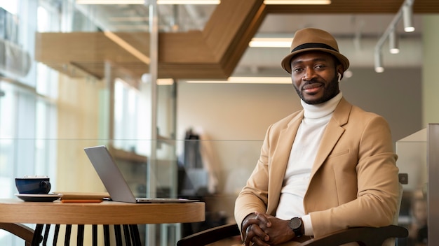 Foto gratuita uomo afroamericano moderno che lavora in un caffe