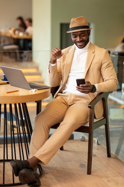 Uomo afroamericano moderno che lavora in un caffe