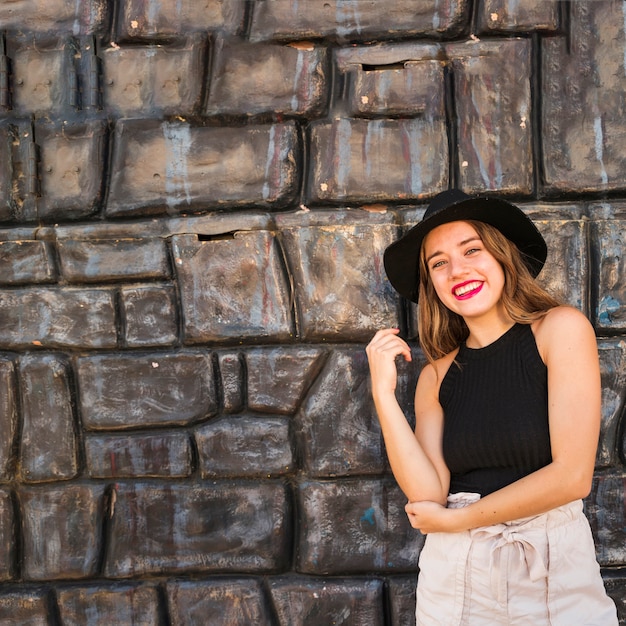 Modern beautiful young woman standing in the front of wall