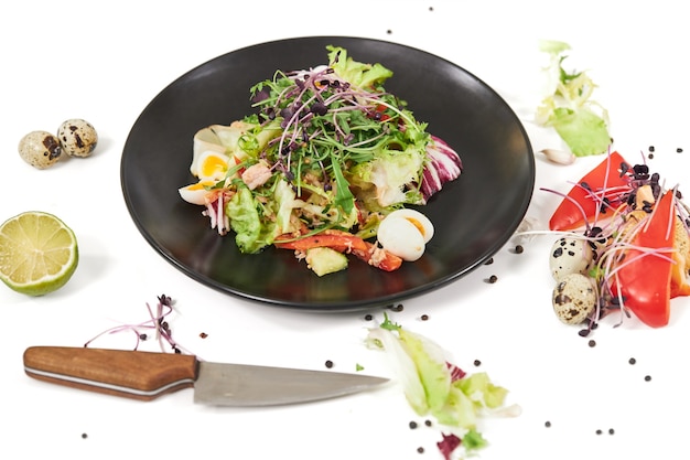 Modern black plate with appezing vegetables salad