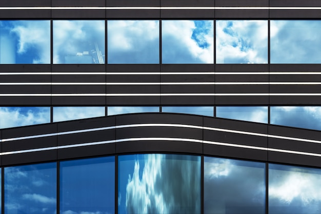 Бесплатное фото Современное здание со стеклянными окнами, тихо наблюдающее за жизнью большого города