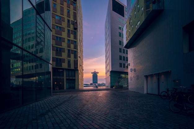 Modern buildings with glass windows under a cloudy sky during the sunset in the evening