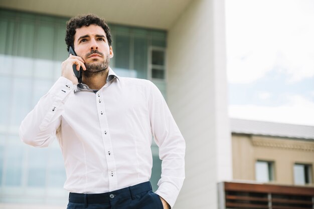 現代のビジネスマンが屋外で電話をかける