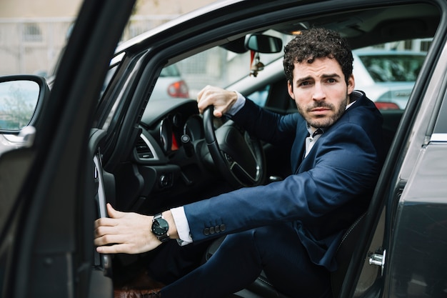 Modern businessman sitting in car