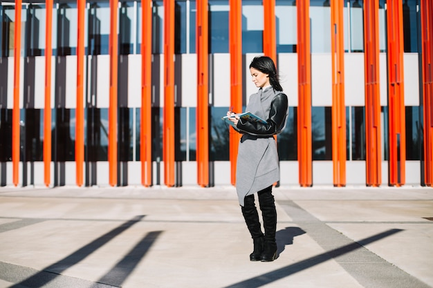 Free photo modern businesswoman using smartphone outdoors