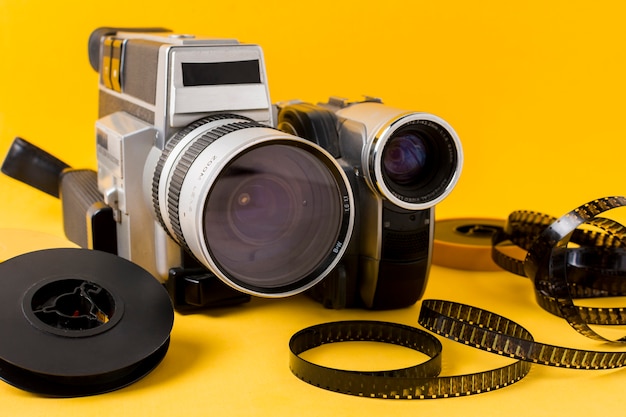現代のカメラ。フィルムリールと黄色の背景上のフィルムストリップ