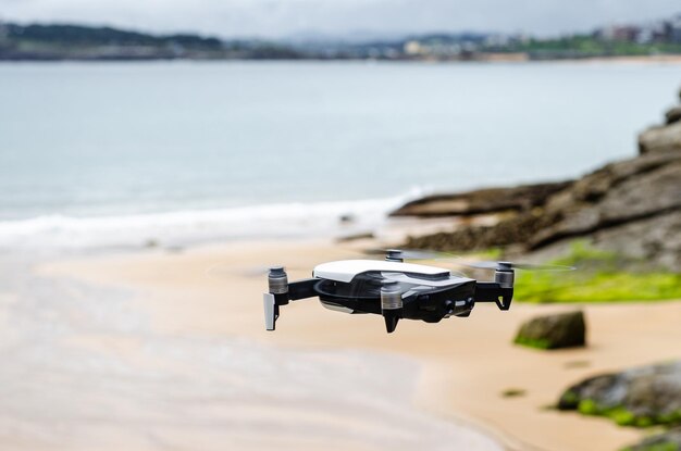 Modern drone flying over rocky seacoast